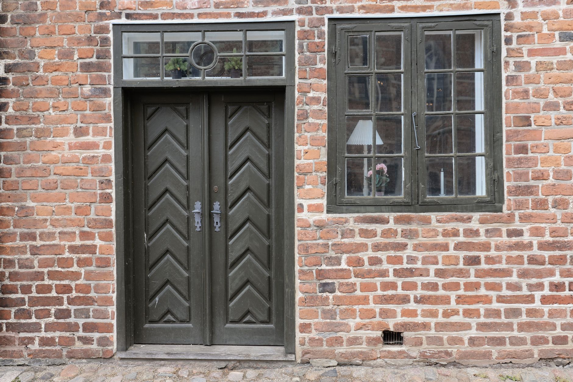 Dør og vindue i en rød murstensfacade
